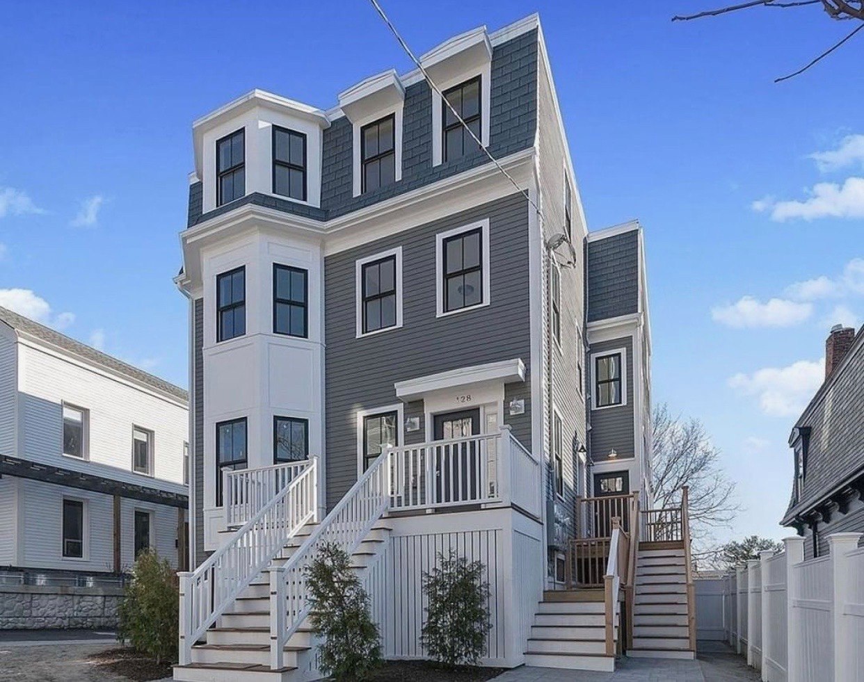 Gray multi-family building with front steps and porches